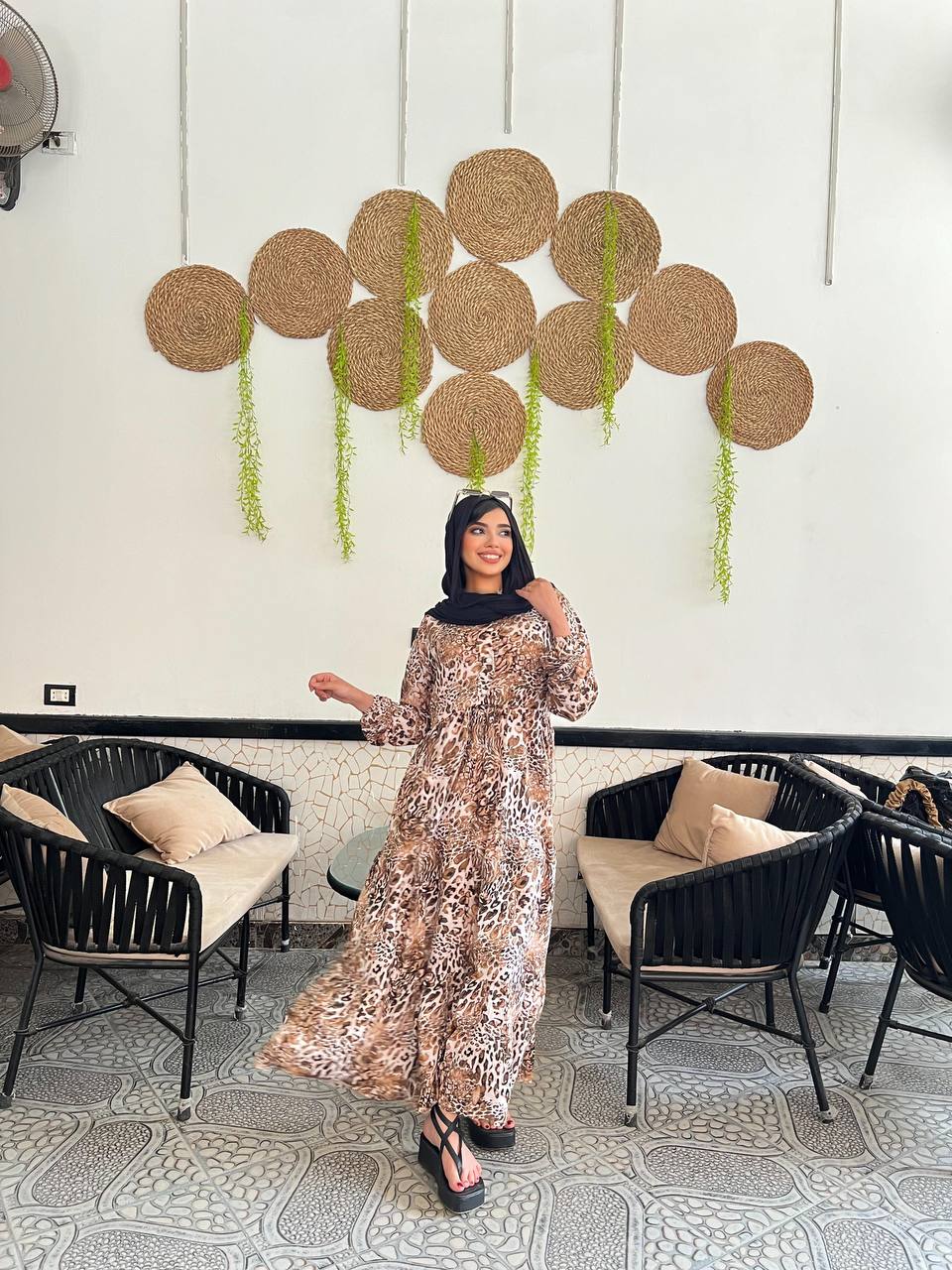 Woman wearing an animal print viscose maxi dress with a relaxed fit, styled with a black hijab and sunglasses.