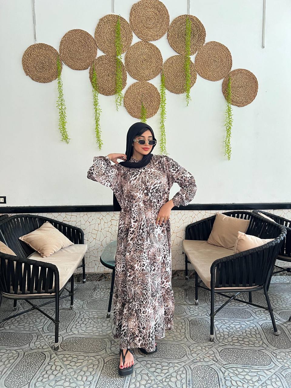 Woman wearing an animal print viscose maxi dress with a relaxed fit, styled with a black hijab and sunglasses.