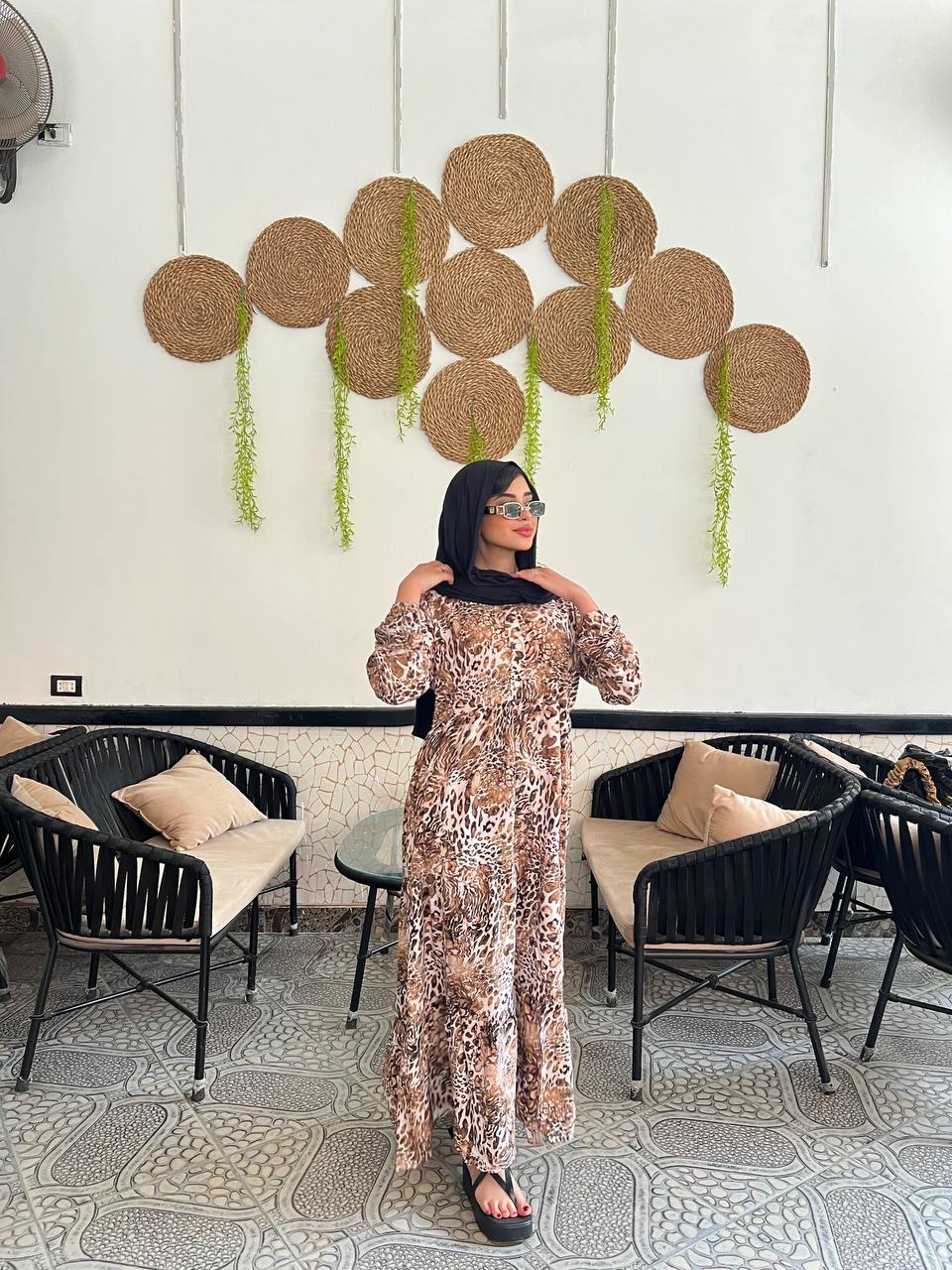 Woman wearing an animal print viscose maxi dress with a relaxed fit, styled with a black hijab and sunglasses.