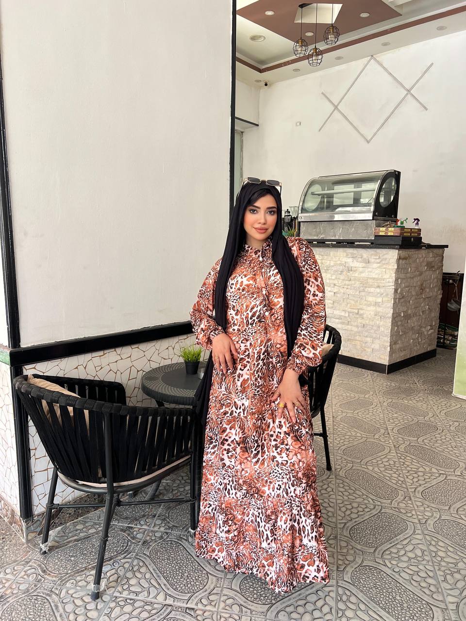Woman wearing an animal print viscose maxi dress with a relaxed fit, styled with a black hijab and sunglasses.