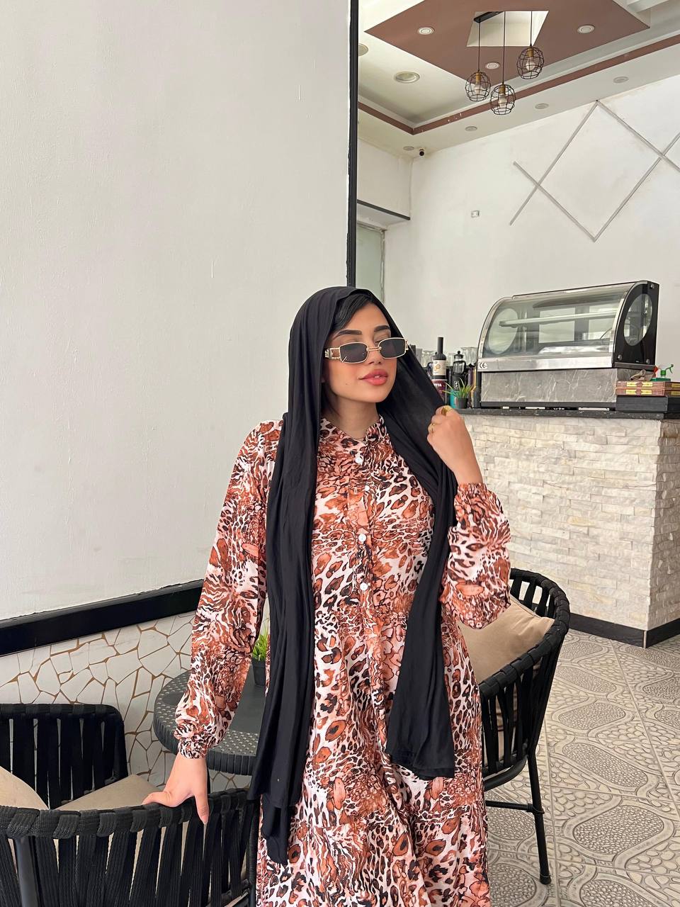 Woman wearing an animal print viscose maxi dress with a relaxed fit, styled with a black hijab and sunglasses.